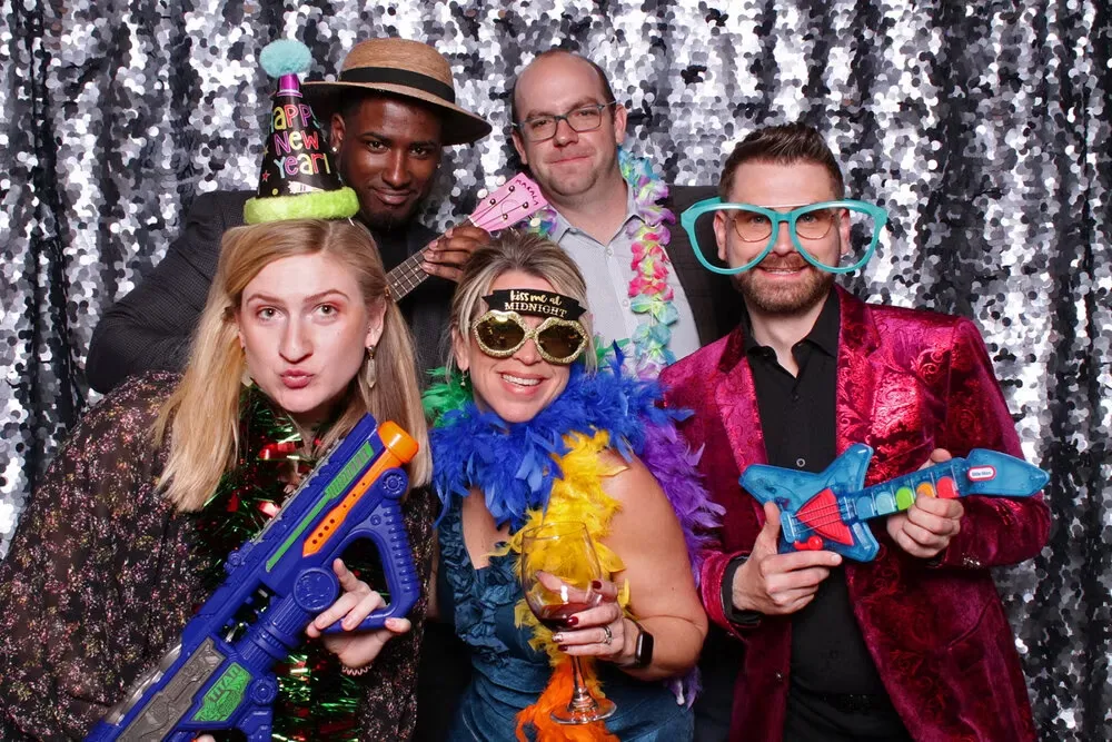 People with silver backdrop and props