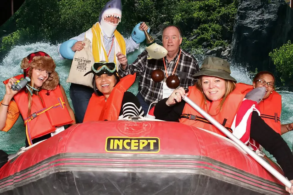 Adventure-themed photo booth with inflatable raft and props creating fun corporate event memories