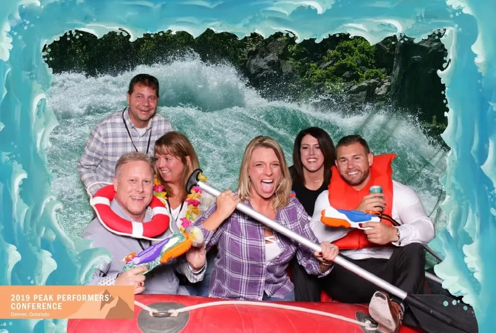 White water raft photo booth with guests loading up and using props like head gear, oars and life preservers for fun event photos