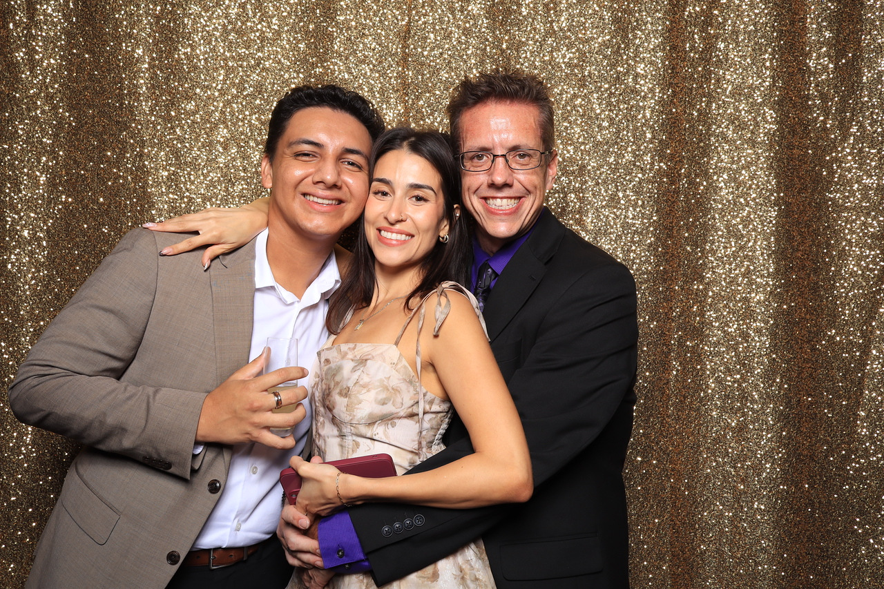 Three guests smiling together in front of a gold sequin backdrop at the Fairmont Century Plaza anniversary party AI photo booth